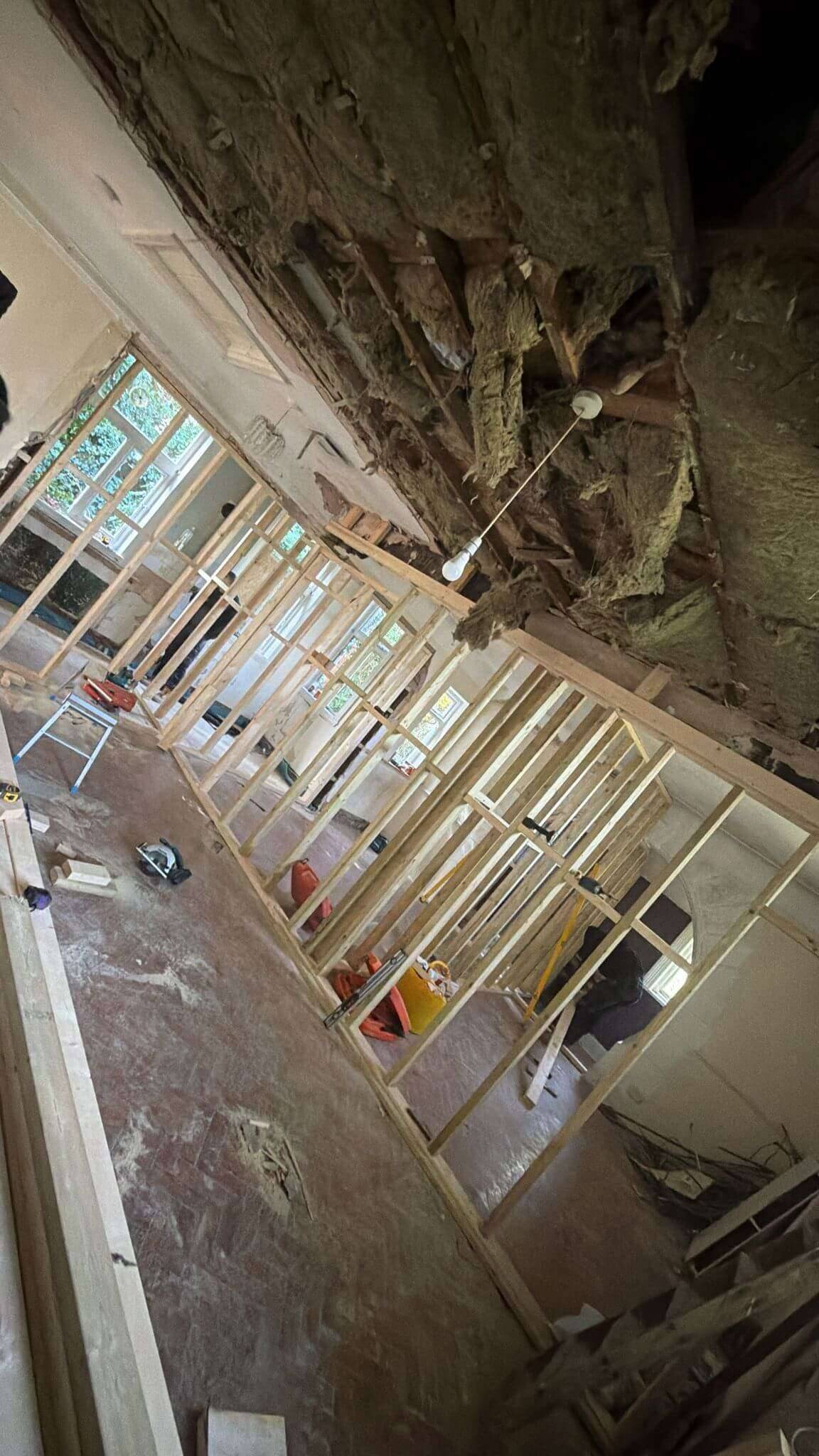 Long run of timber stud partition walls framing out new rooms beneath an opened-up ceiling